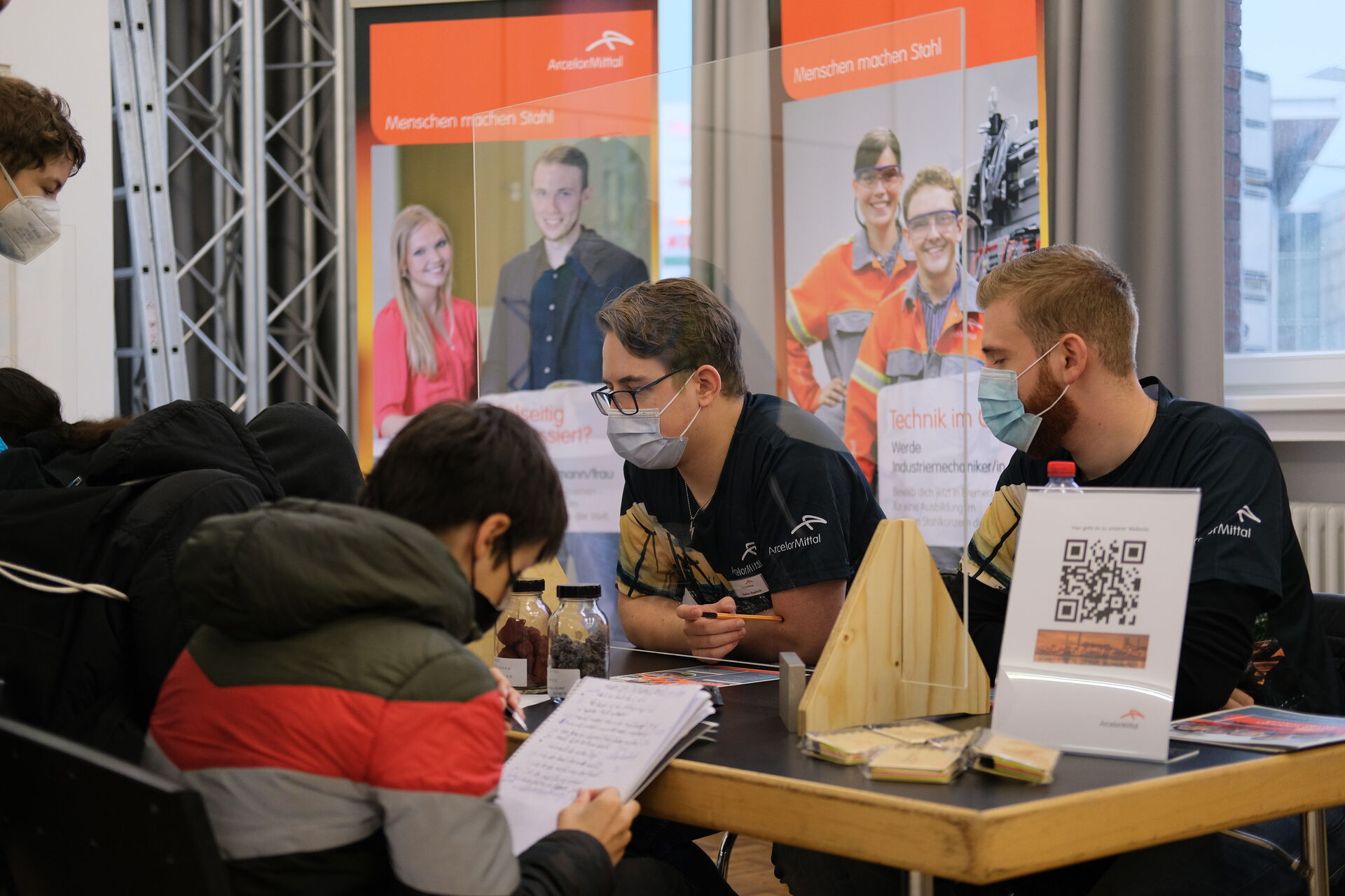 Auszubildende eines Betriebes informieren die neuen potenziellen Azubis am Messestand